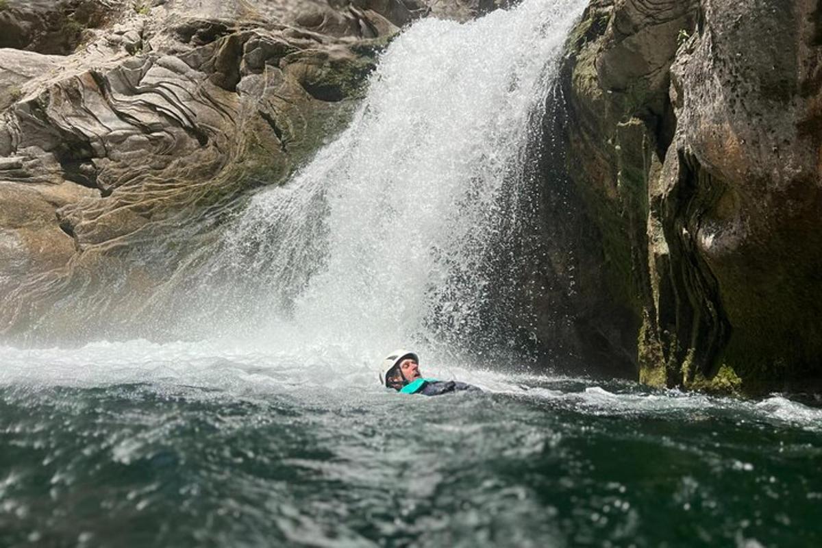una dona estirada a l'aigua davant d'una cascada
