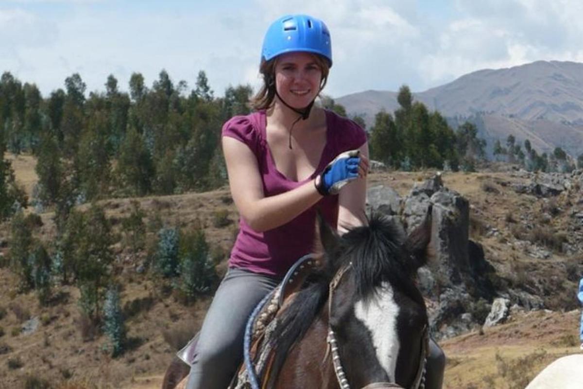 una dona muntant a cavall en un camp