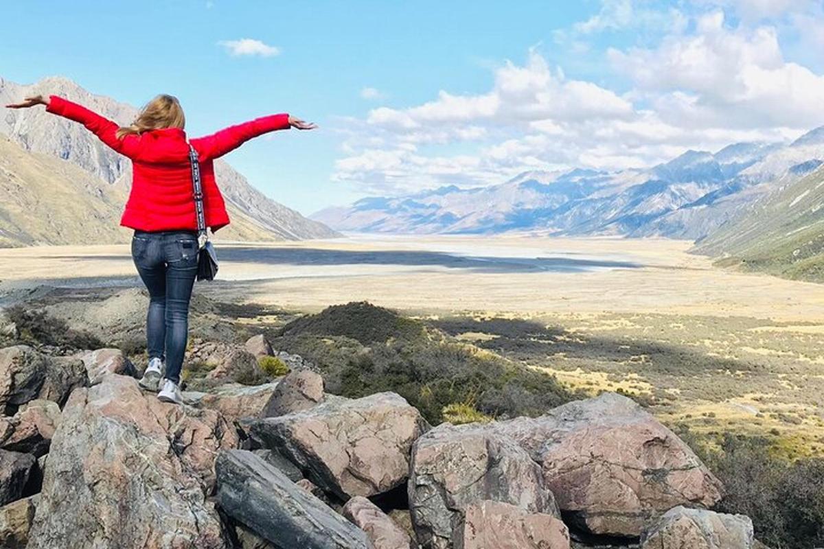 una donna in piedi sulla cima di una montagna con le braccia tese
