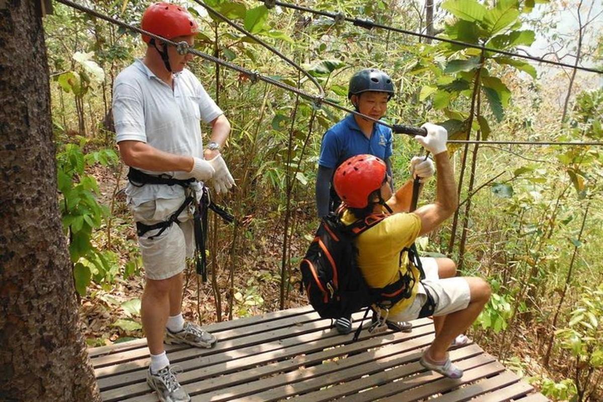 two men on a zip line in the forest