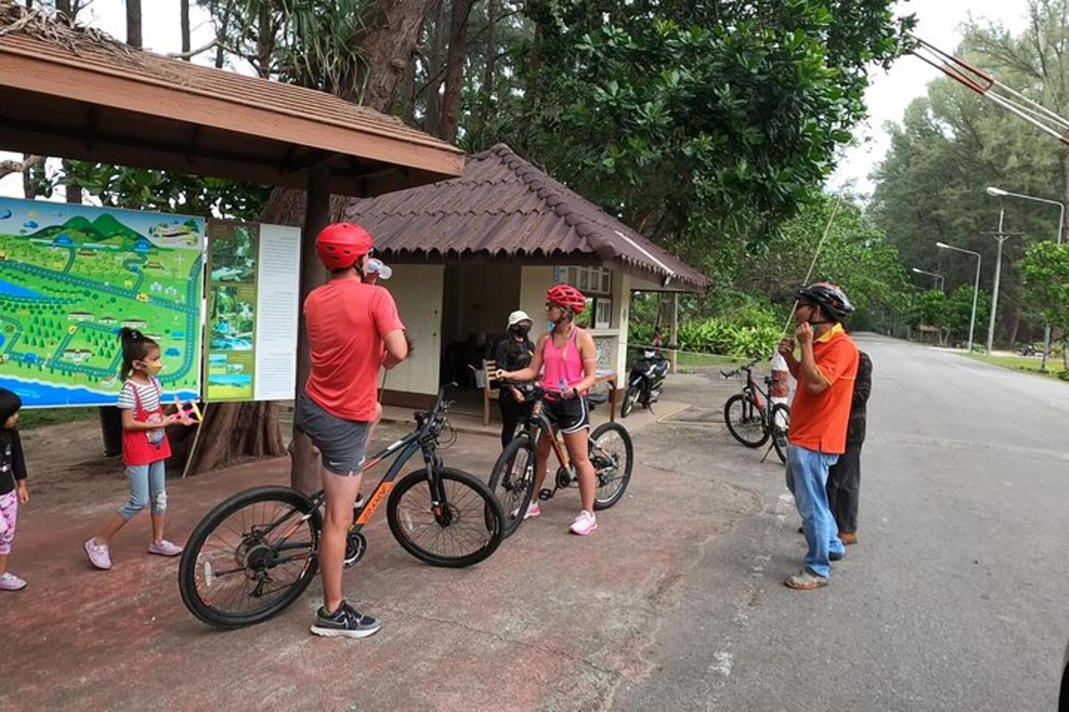 a group of people standing at a bus stop with their bikes