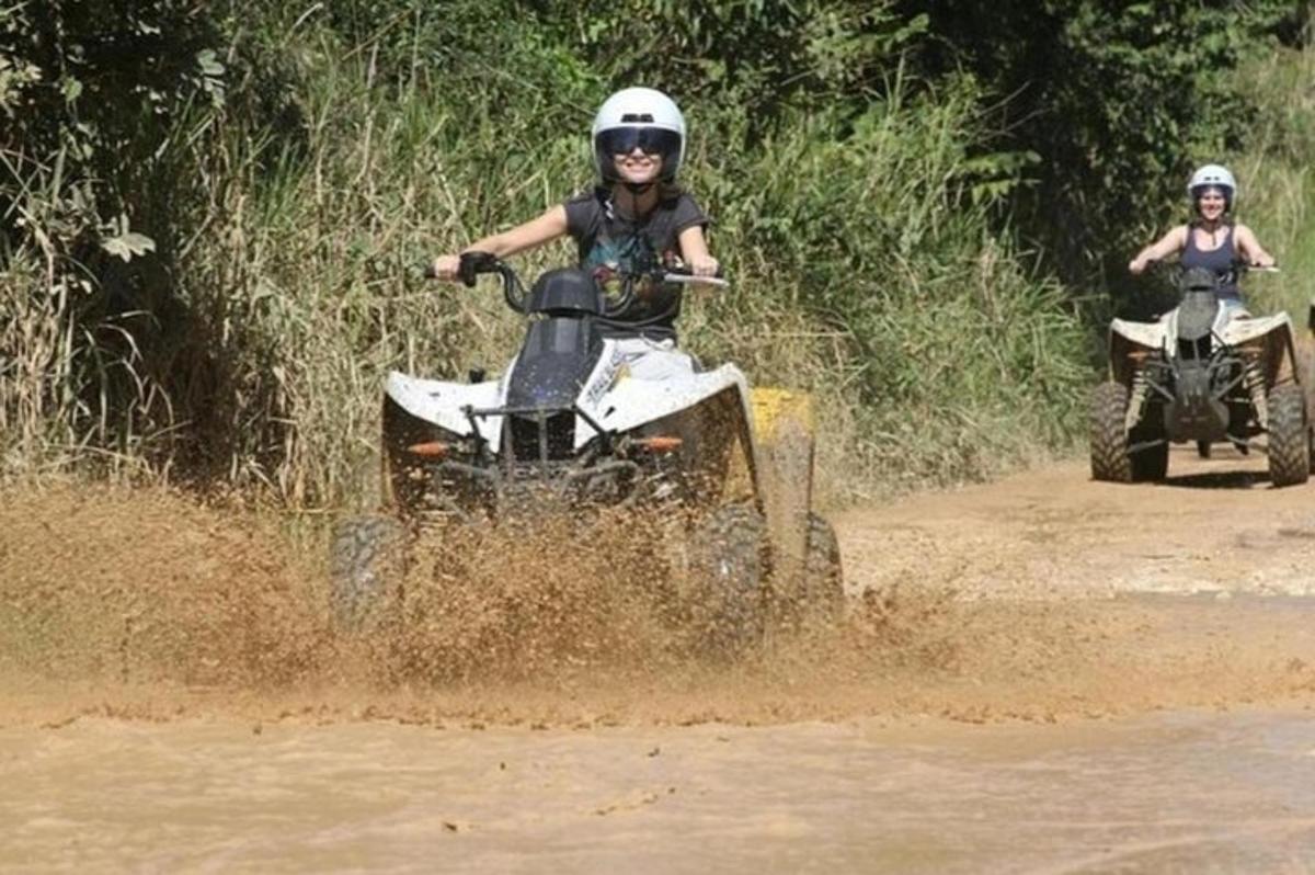 dua orang menaiki atv dalam lumpur