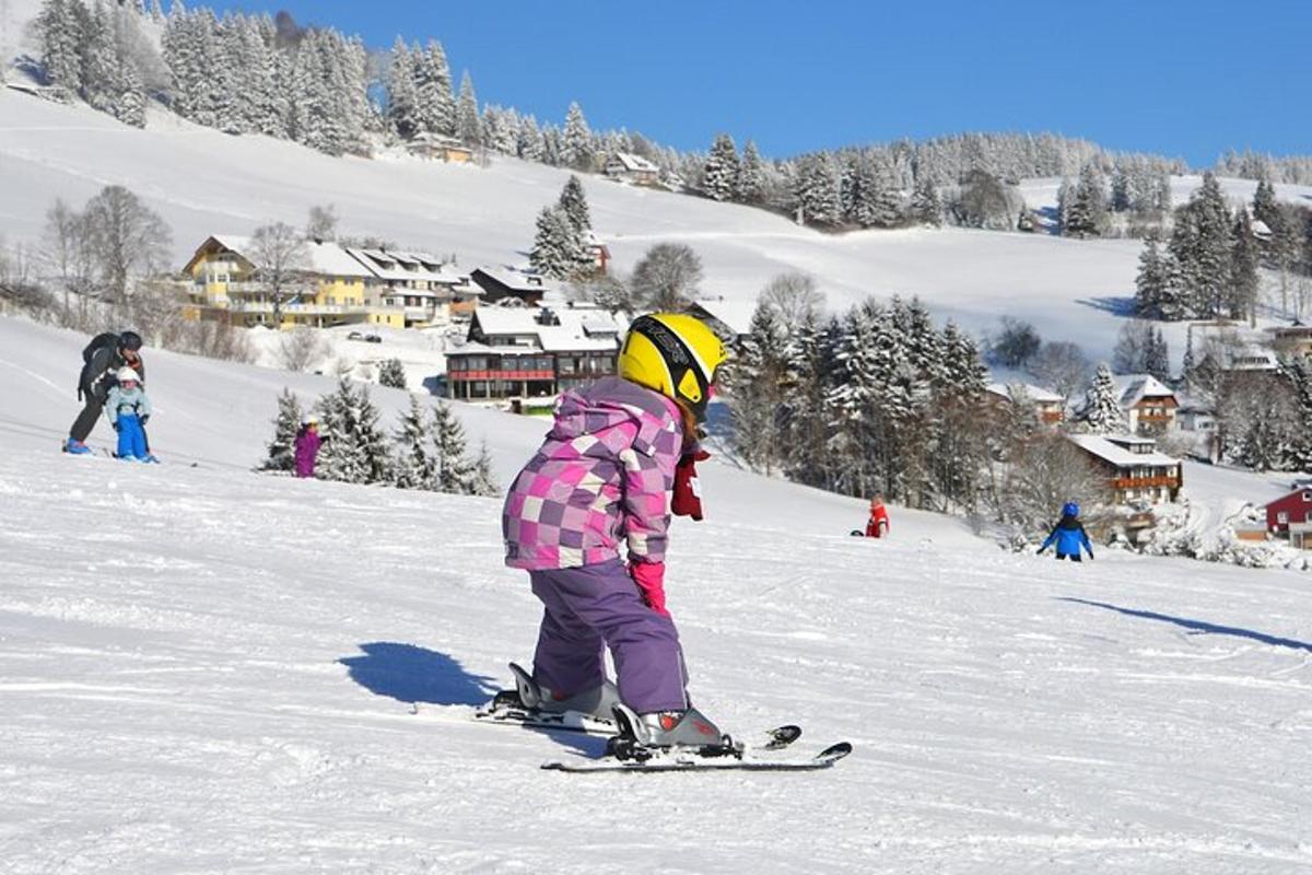 a child on skis in the snow on a ski slope