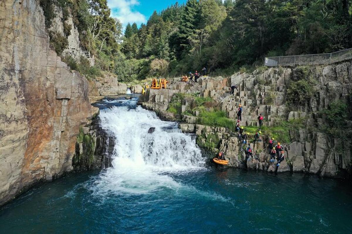 eine Gruppe von Menschen auf einem Floß in einem Wasserfall