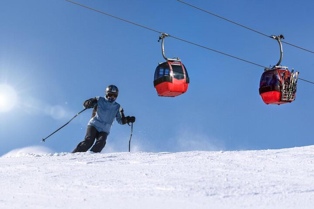 a person skiing down a snow covered slope under a ski lift