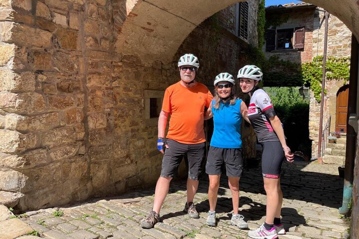 tre persone che indossano caschi in piedi sotto un arco
