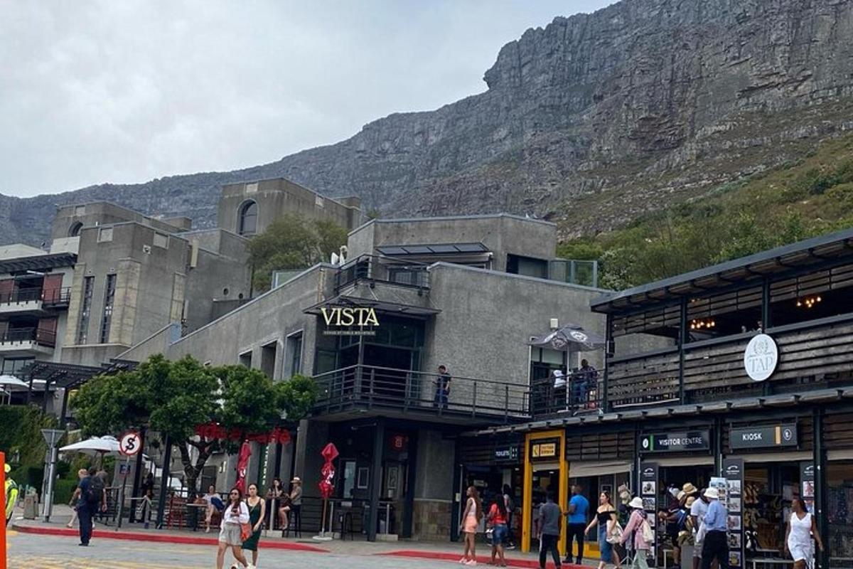 a group of people standing outside of a building with a mountain