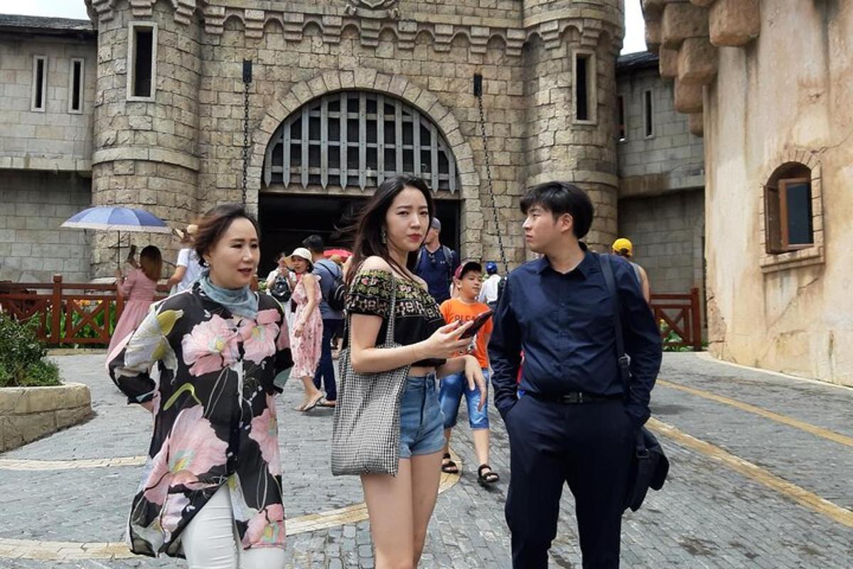 một người đàn ông và hai người phụ nữ đang đi bộ trước một tòa nhà