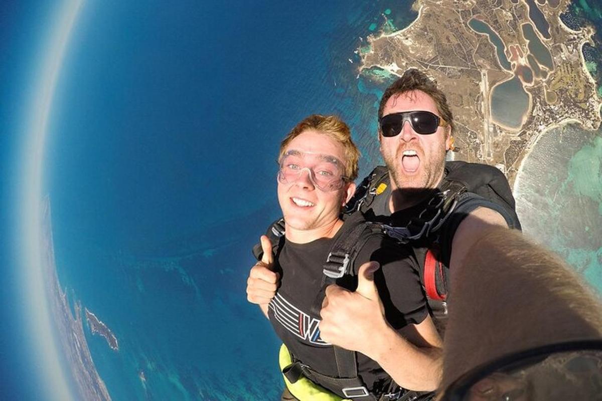 dva človeka, ki kažeta palec gor med letom nad oceanom