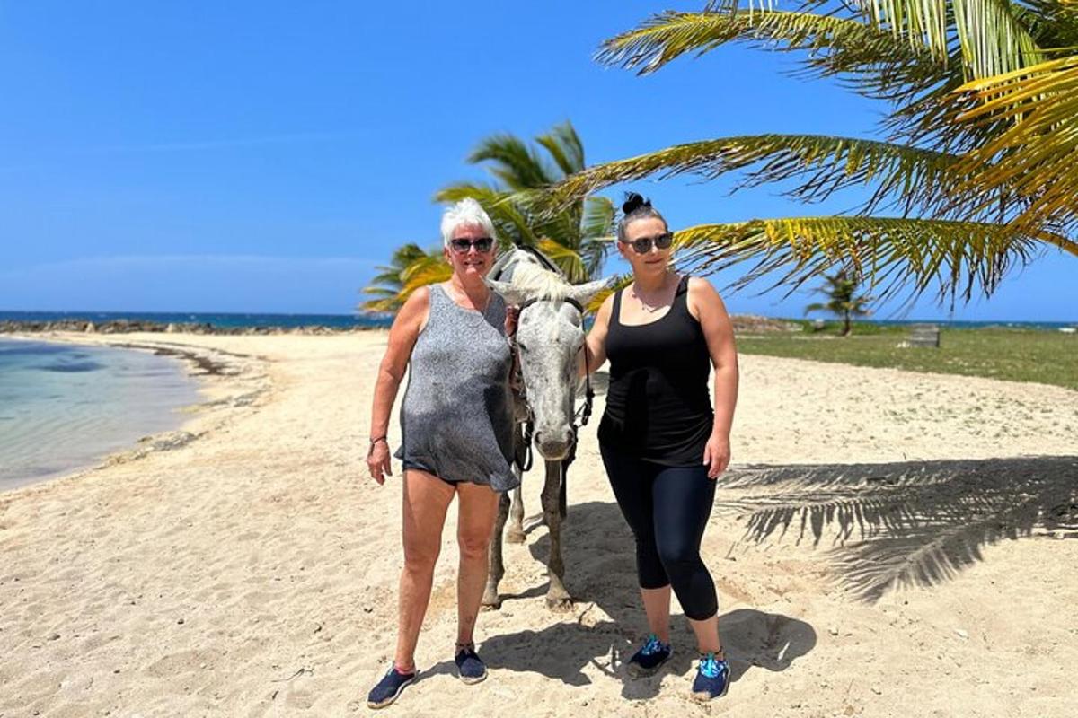 zwei Frauen stehen mit einem Pferd am Strand