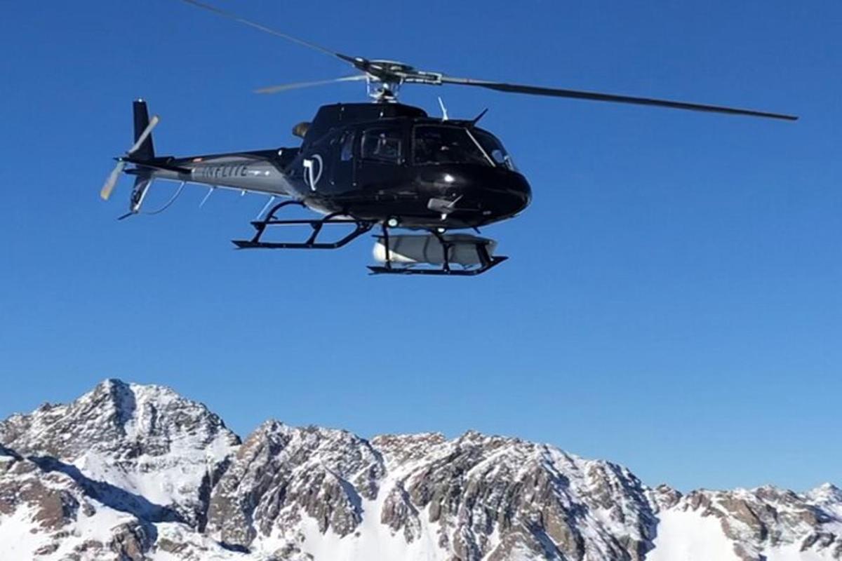helikopteri lentää lumen peittämän vuoren yllä