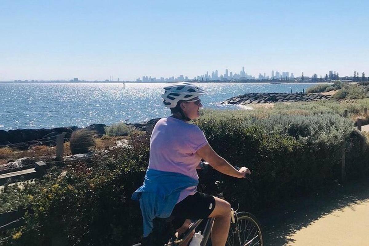 uma mulher andando de bicicleta em uma trilha perto da água