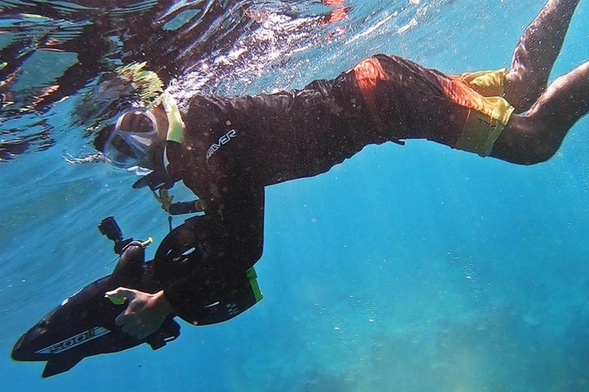 osoba v neoprene plávajúca vo vode