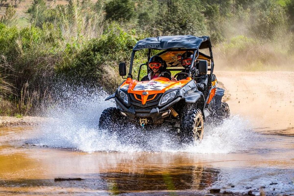 dues persones en un quad conduint per l'aigua