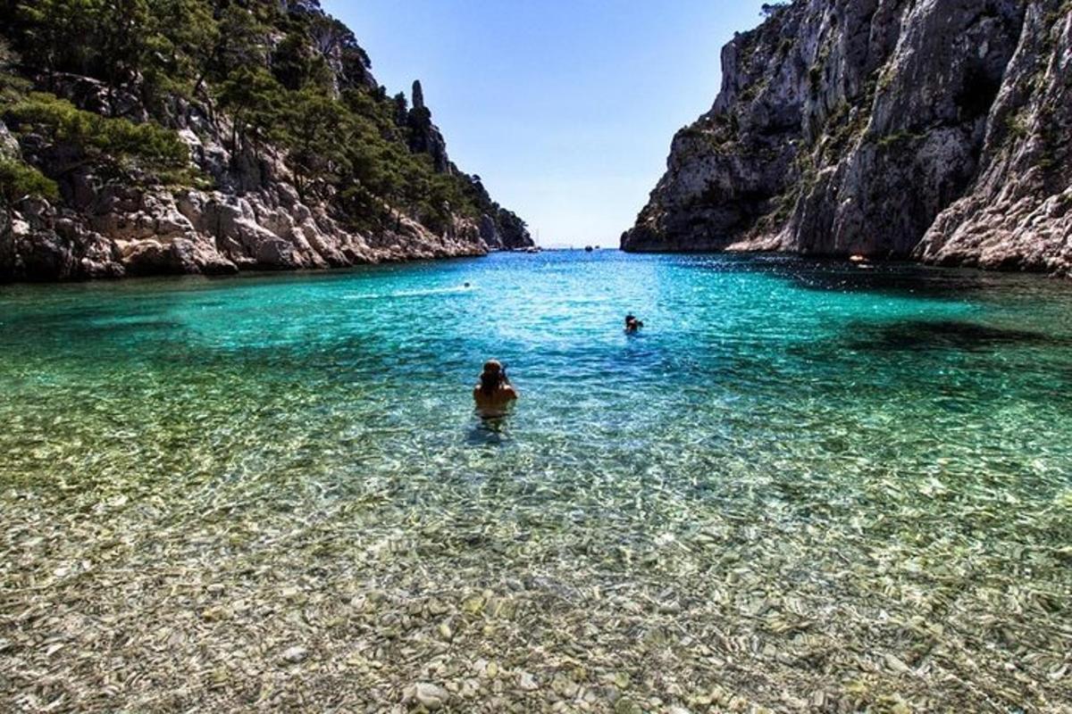 due persone che nuotano nell'acqua vicino a una montagna
