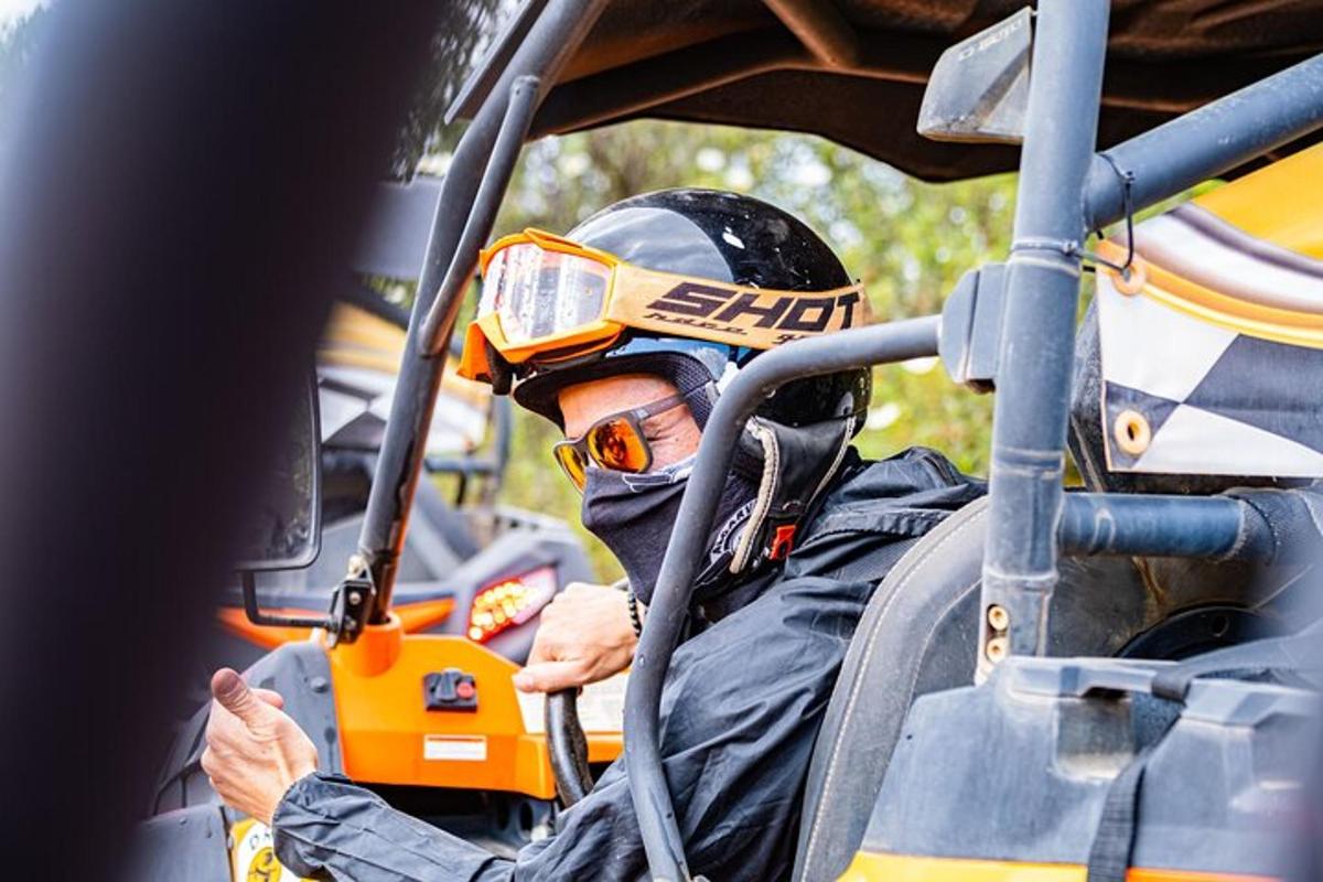 un home amb casc i ulleres de protecció assegut en un vehicle