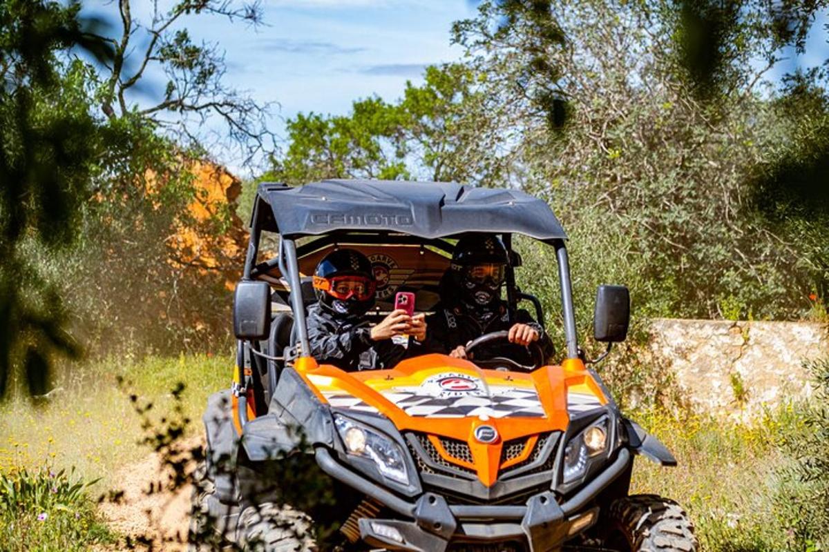 twee mensen in een oranje ATV rijden over een pad