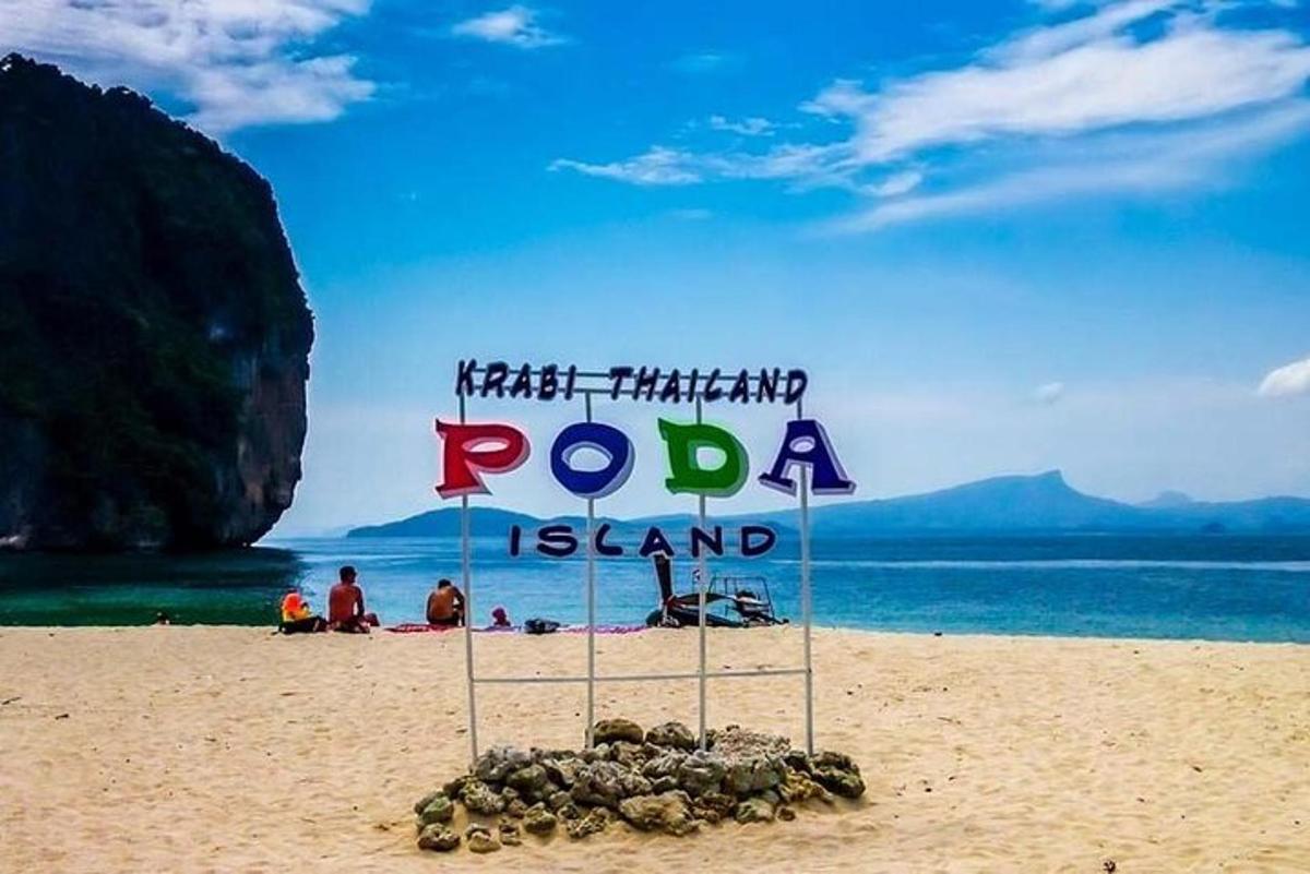 un cartello su una spiaggia con persone sulla spiaggia