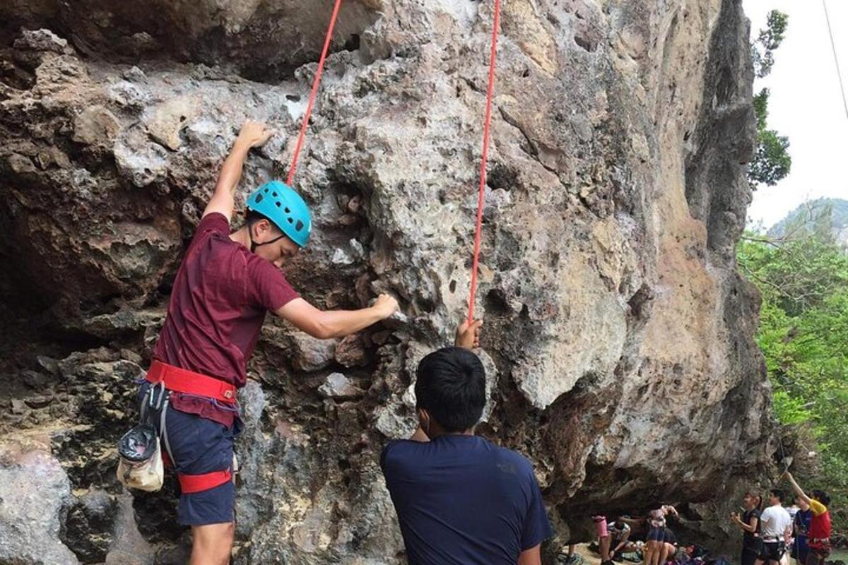 two boys are climbing on a rock wall