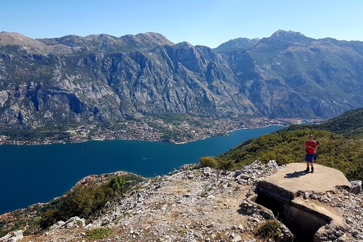 inimene, kes seisab mäe tipus ja vaatab veekogule