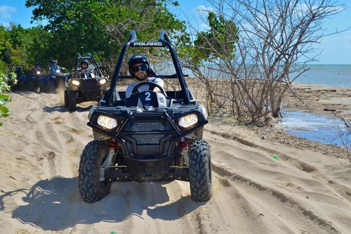 twee mensen rijden op quads op het strand