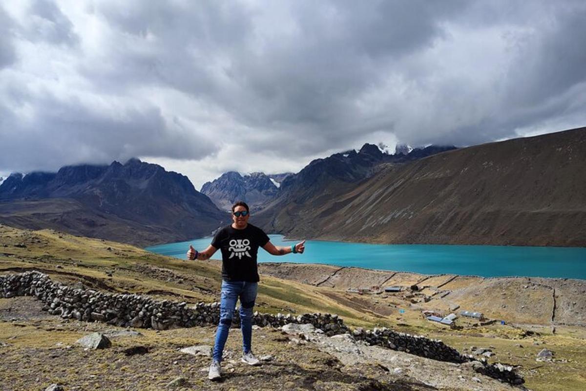 seorang lelaki berdiri di atas gunung dengan tasik