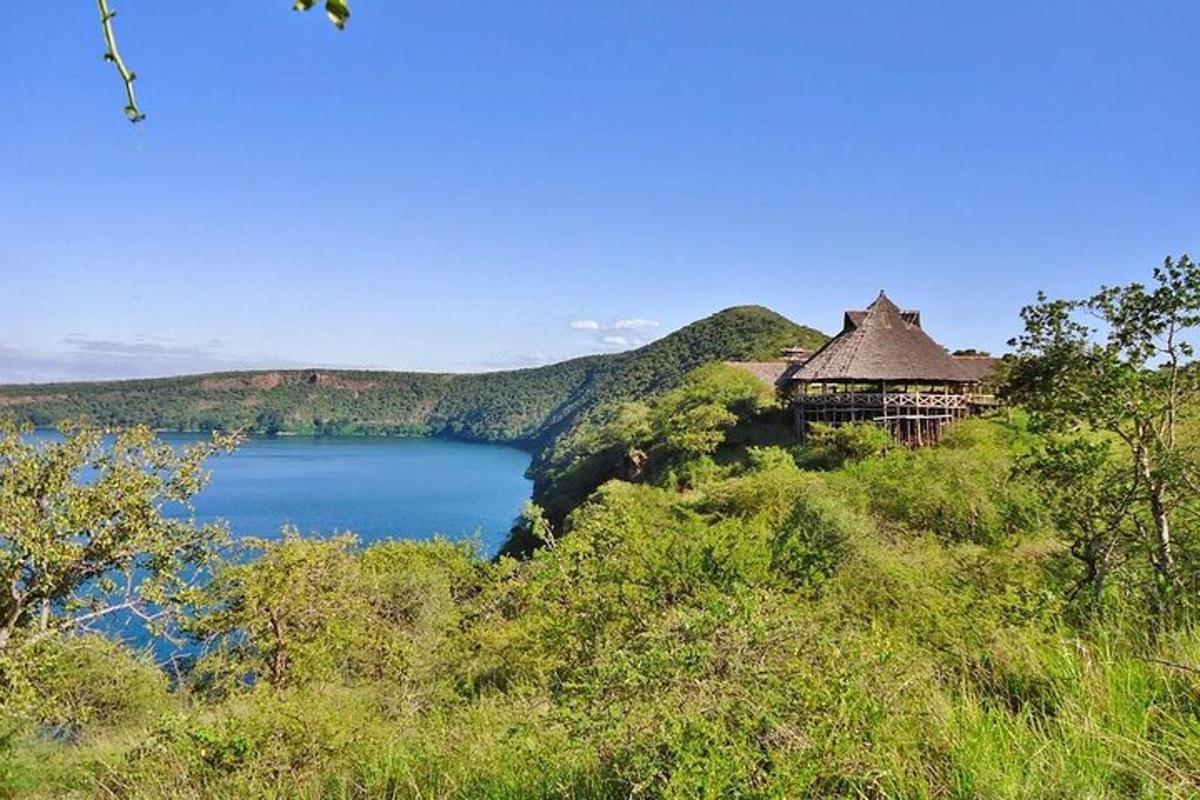 uma casa no topo de uma colina perto de um lago