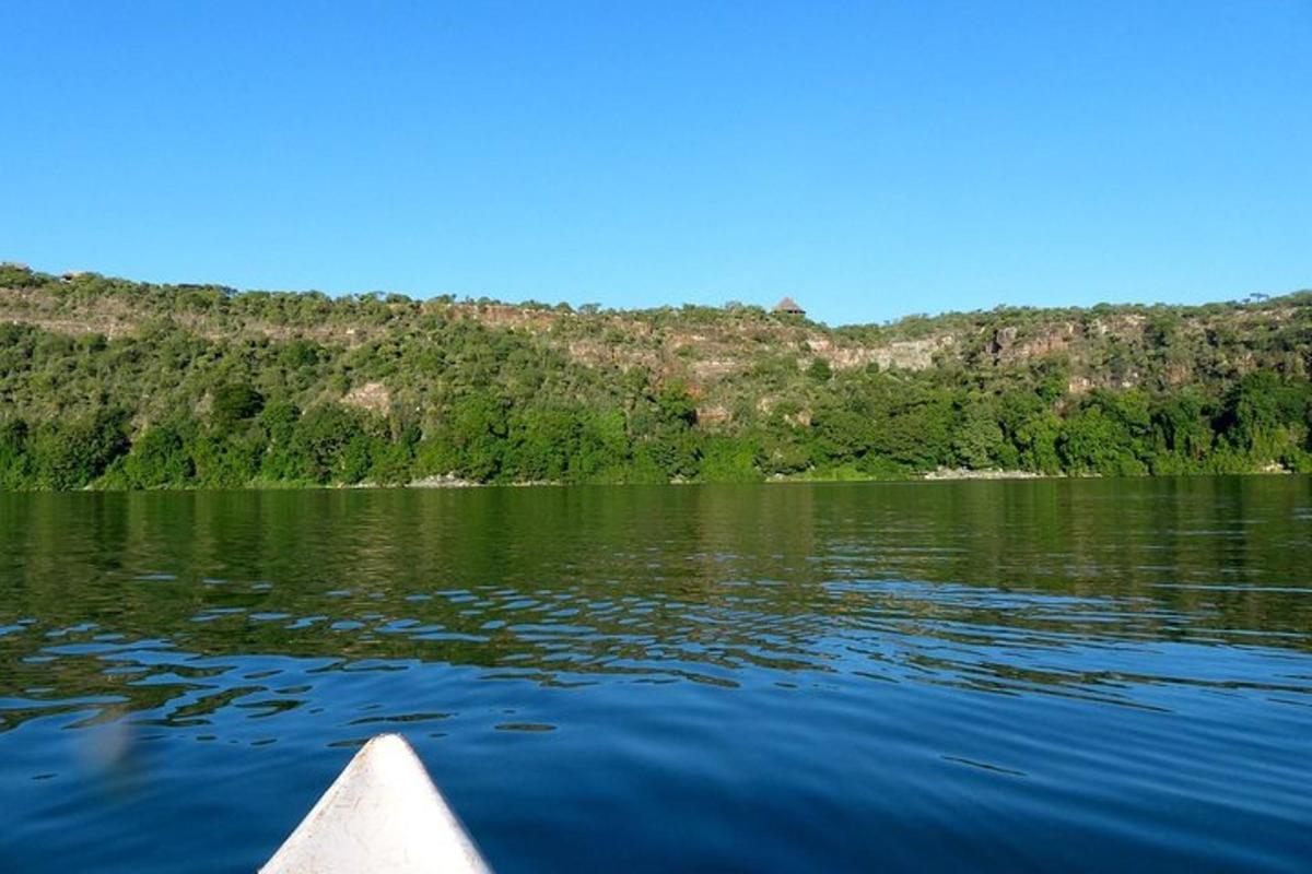 um barco a remo em um lago com montanhas ao fundo