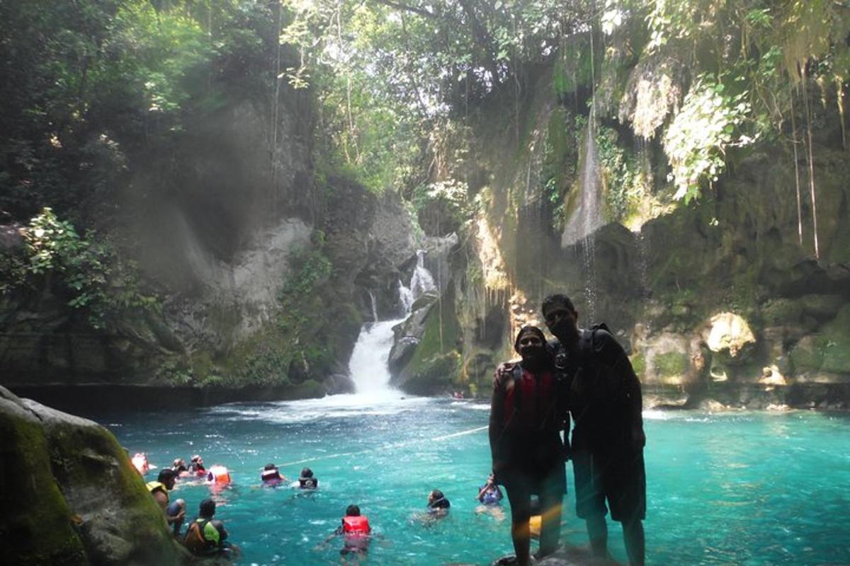 a group of people standing in front of a waterfall