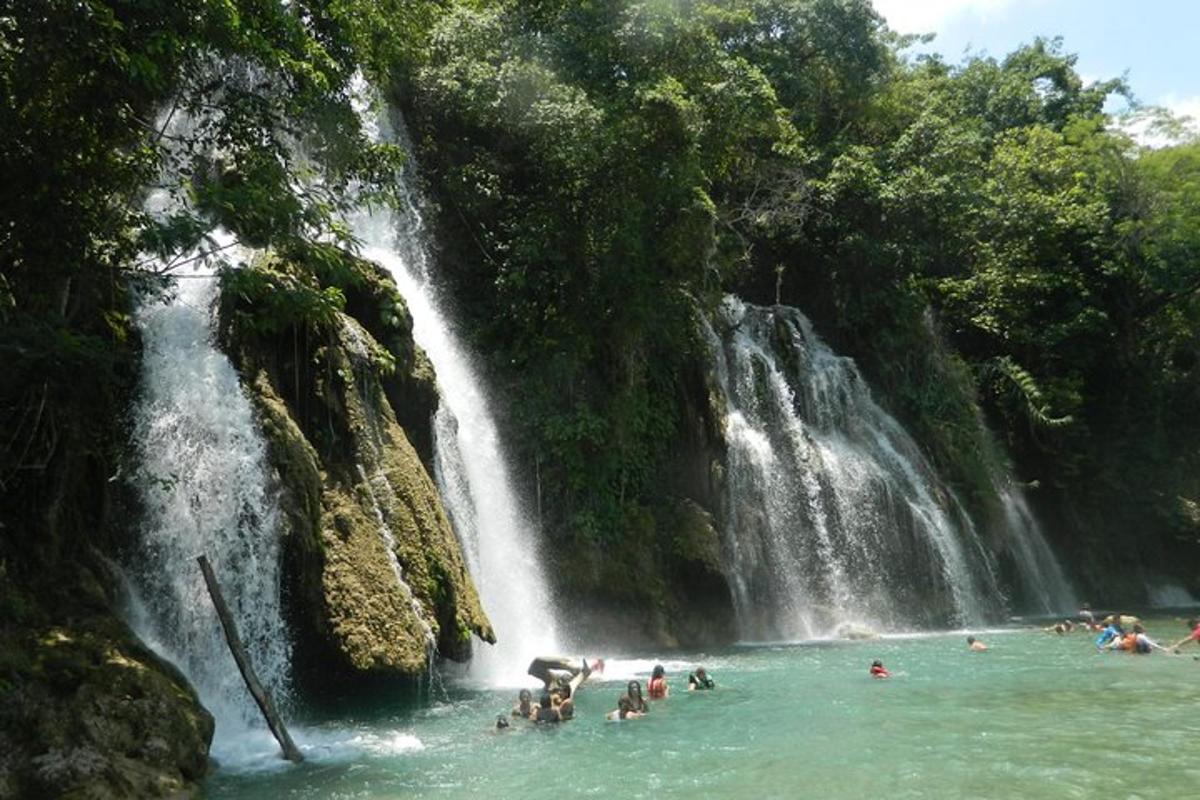 a group of people swimming in a waterfall