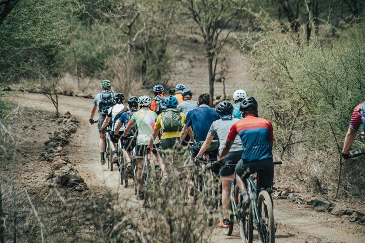 skupina ľudí jazdiacich na bicykloch po prašnej ceste
