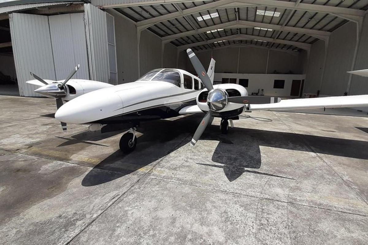 et lite hvitt fly parkert i en hangar