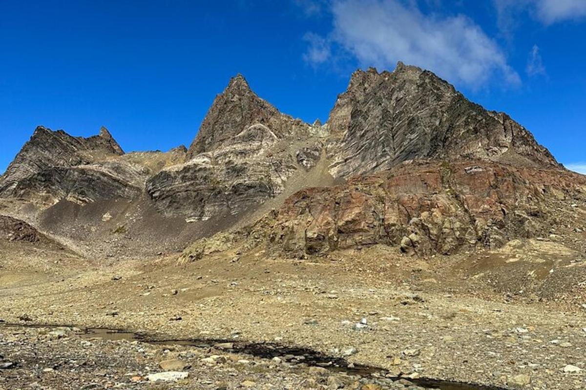 a rocky mountain with a blue sky in the background