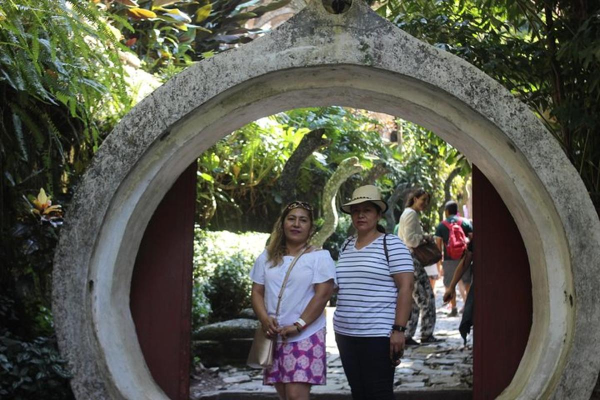 two women walking through an archway in a garden
