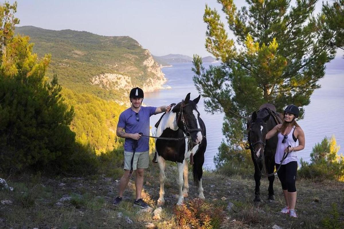 moški in ženska stojita poleg konja