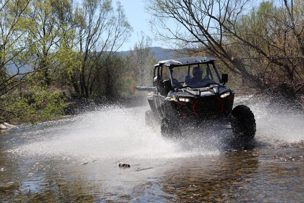 một người trên xe jeep đang lái xe qua sông