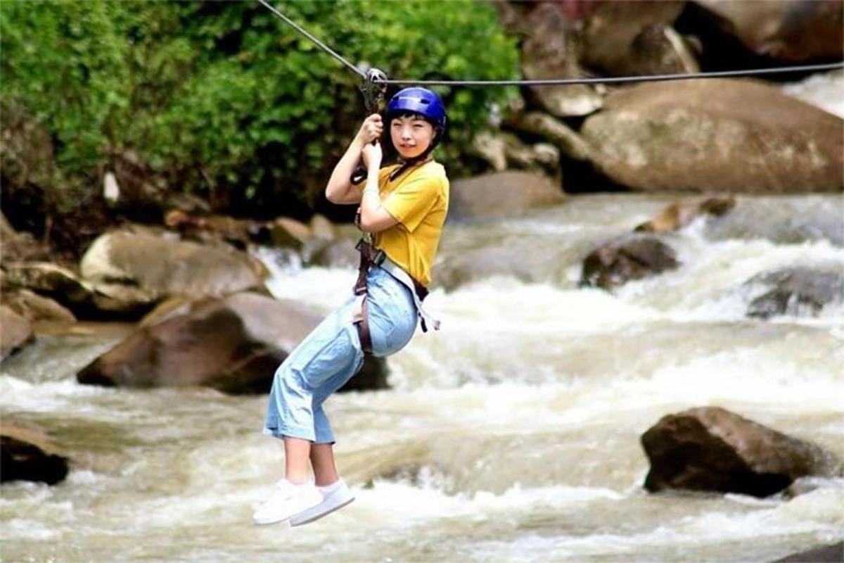 คนกำลังกระโดดลงไปในแม่น้ำด้วยซิปไลน์