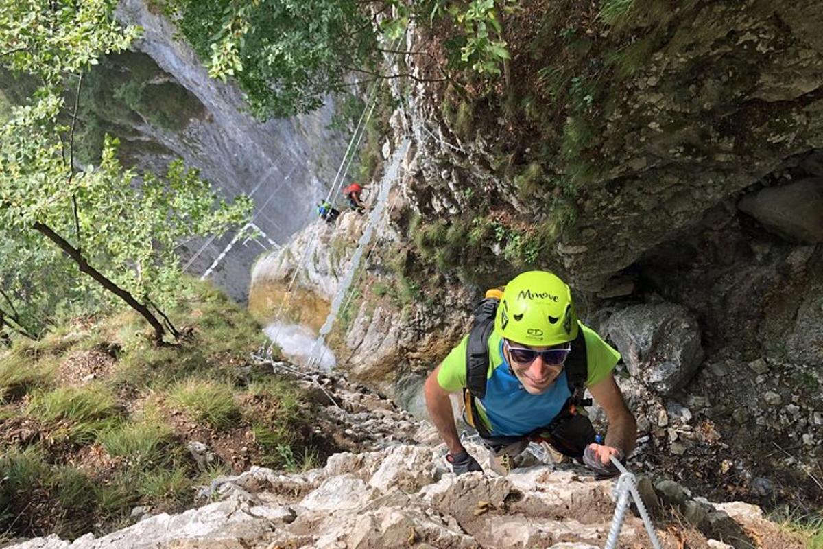 seorang lelaki bertopi keledar kuning sedang mendaki gunung