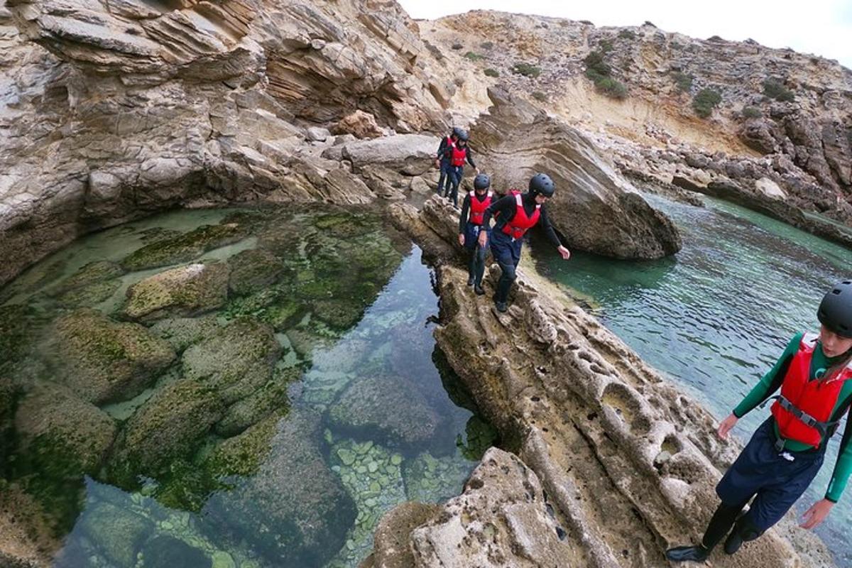 un grup de persones caminant per una muntanya rocosa