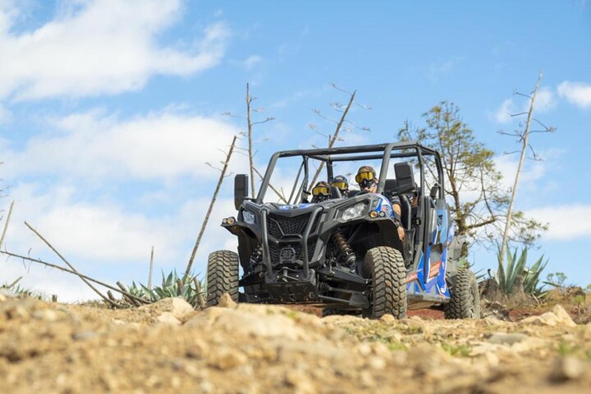 a person in a jeep driving down a dirt hill