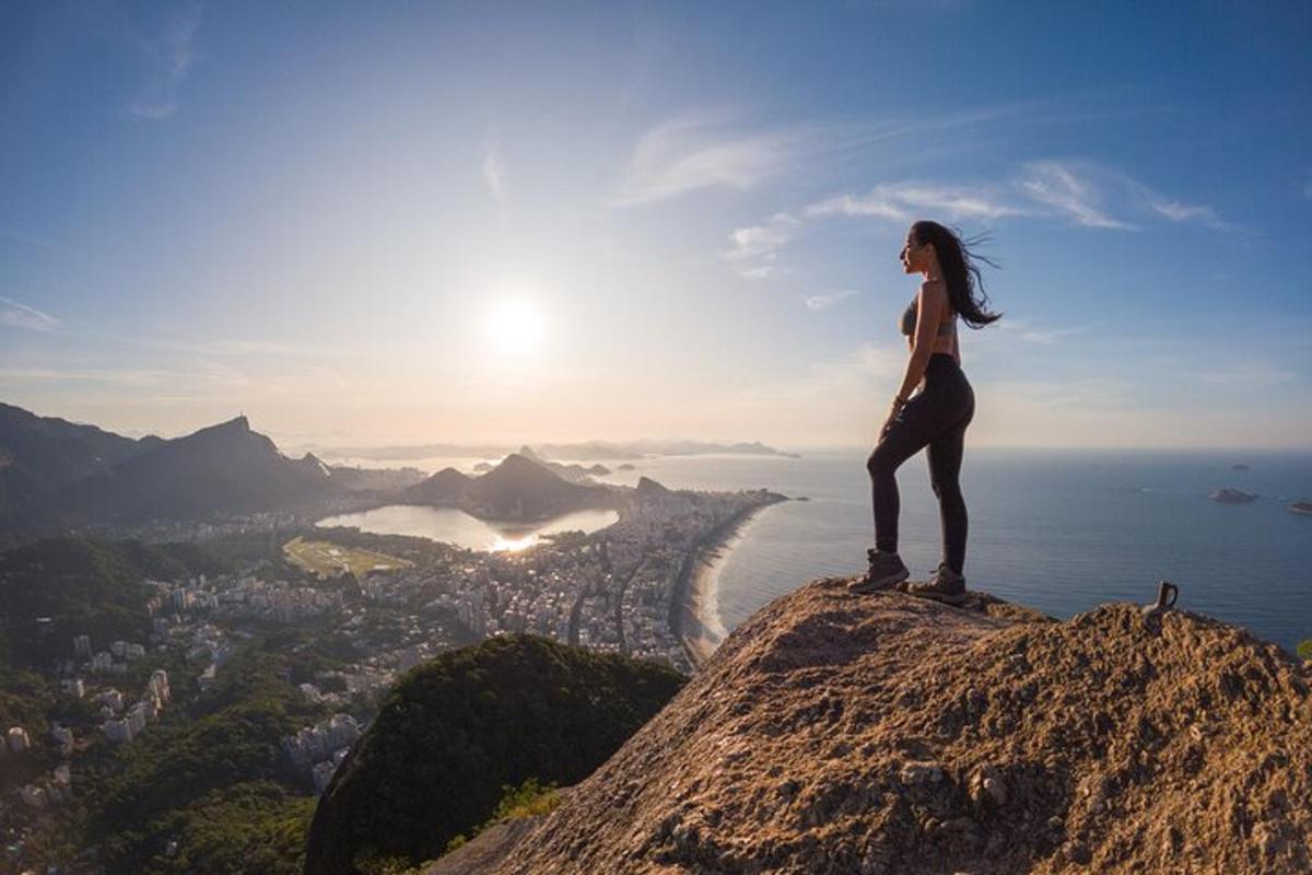 una donna in piedi sulla cima di una montagna che guarda il panorama