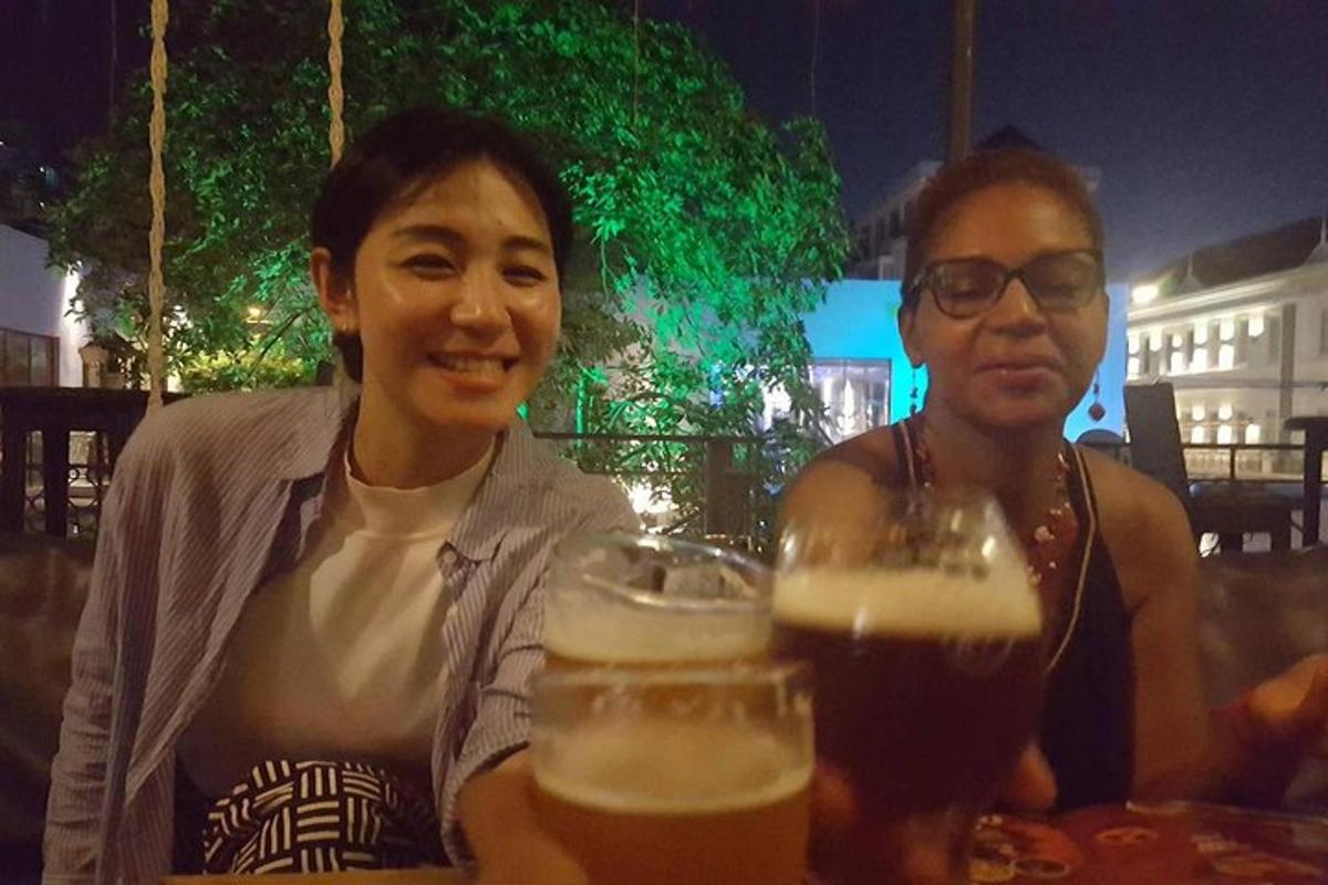 due persone sedute a un tavolo con bicchieri di birra