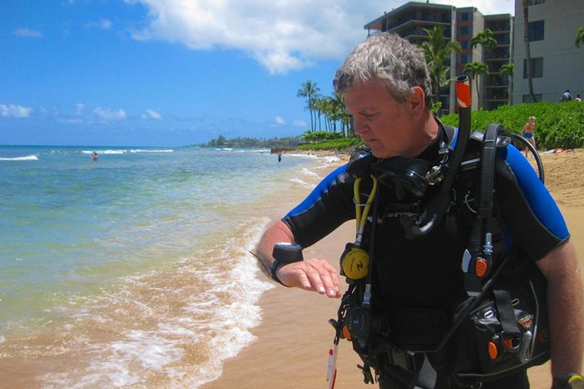 Un hombre parado en la playa con una cámara