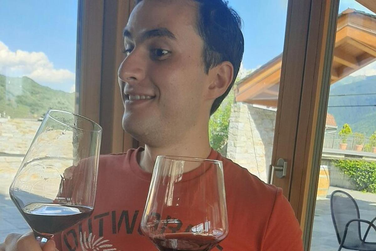 muž drží dva poháre vína