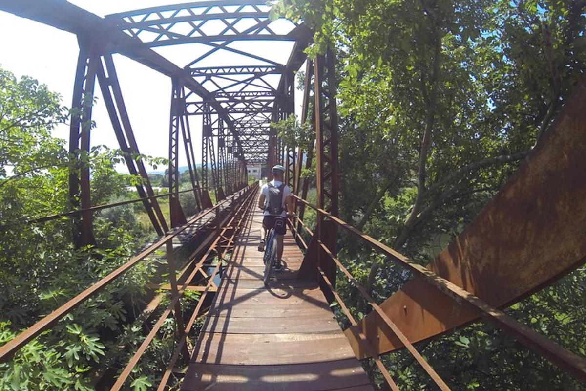 muž jazdiaci na bicykli na moste