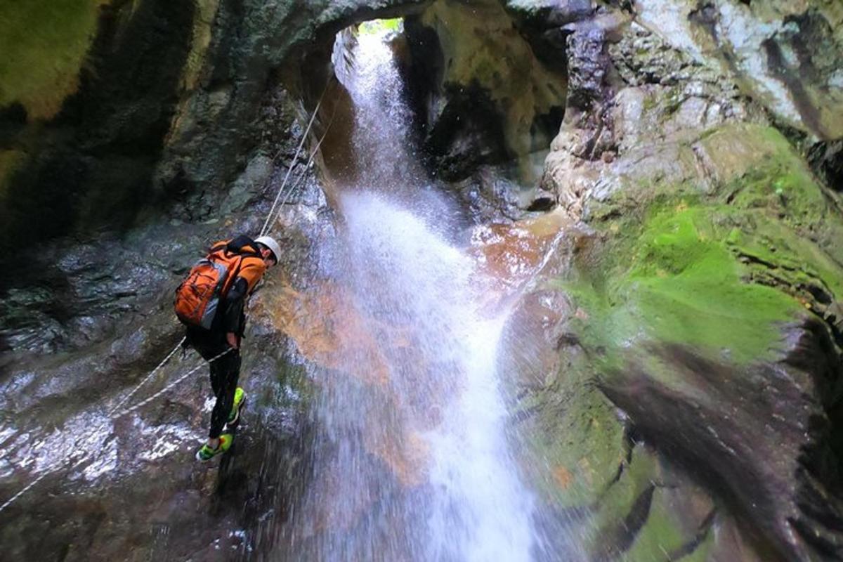 un uomo con uno zaino in piedi davanti a una cascata