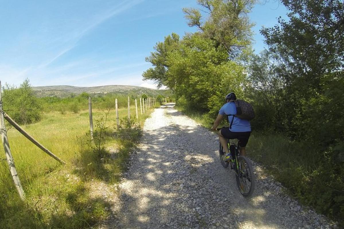 osoba jazdiaca na bicykli po prašnej ceste