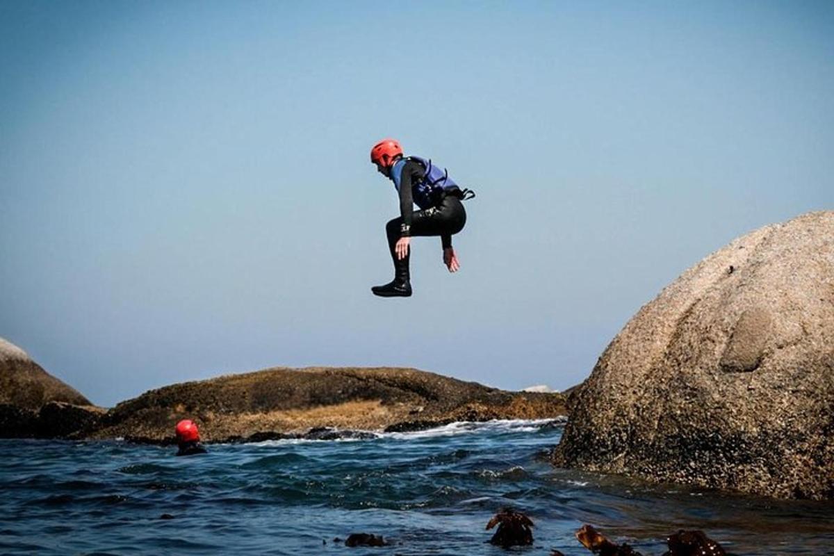 un uomo che salta da una roccia in acqua