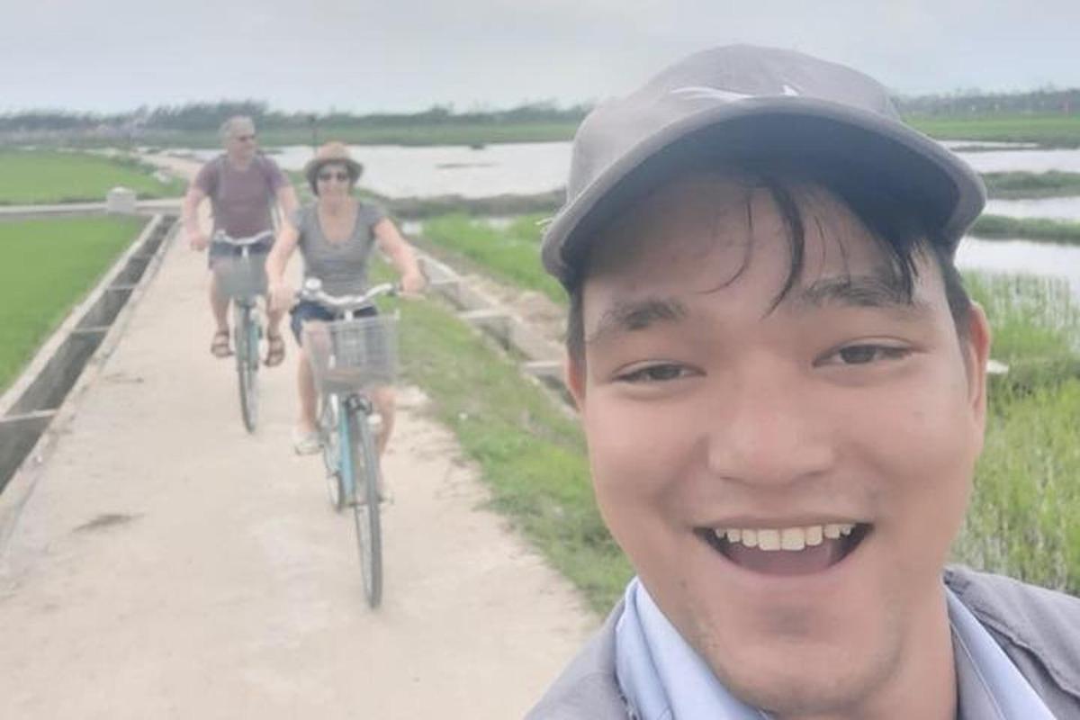 two people riding bikes down a dirt road