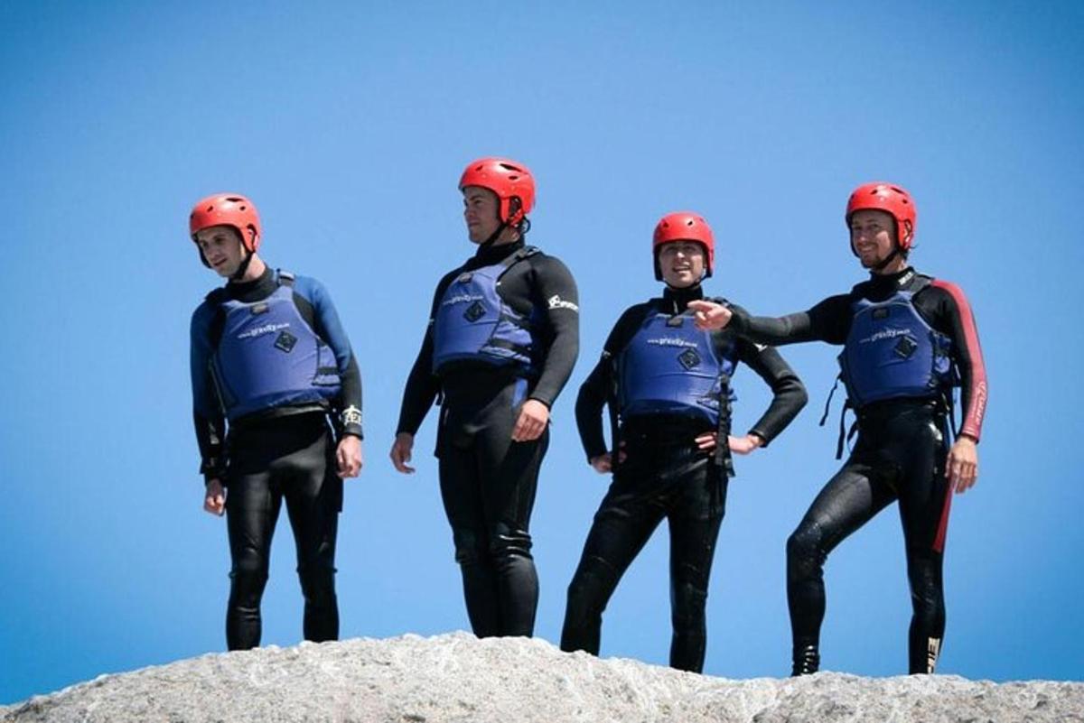 un gruppo di uomini in mute e caschi in piedi sulle rocce